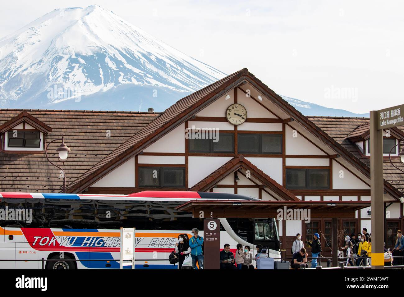 Stazione di Kawaguchiko in Giappone con il picco di neve del Monte Fuji visibile dietro, autobus autostradale di Tokyo con imbarco dei turisti, Giappone, Asia, 2023 Foto Stock