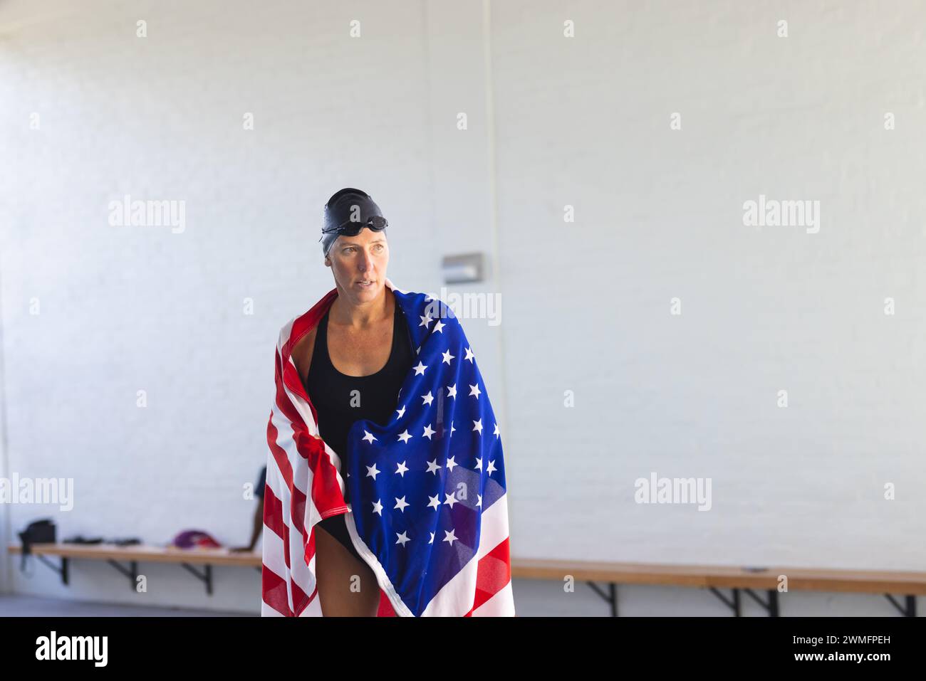 Nuotatrice atleta caucasica avvolta in una bandiera americana, con spazio copia Foto Stock