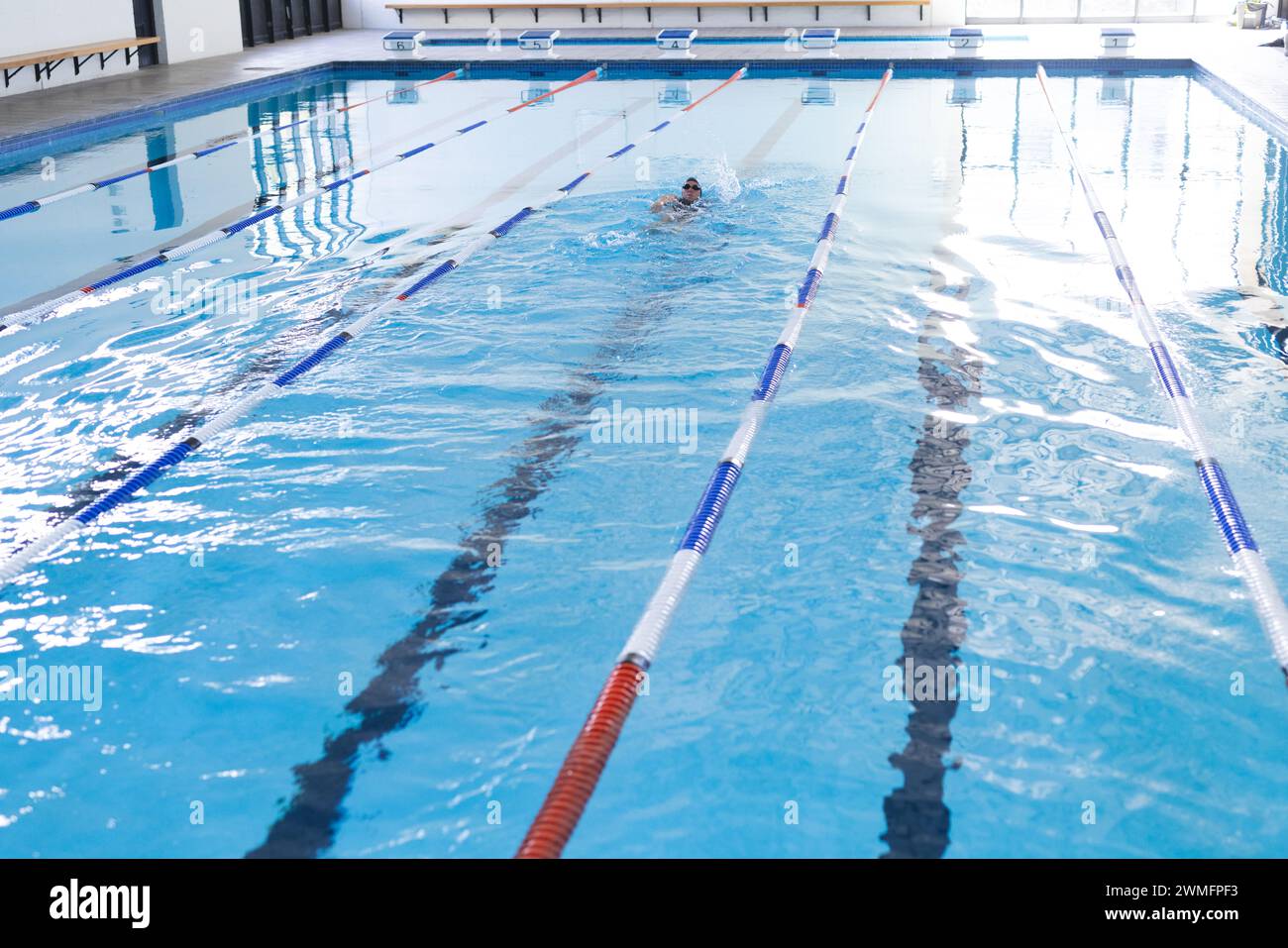 La persona pratica il nuoto in una piscina coperta trasparente, con spazio per fotocopie Foto Stock