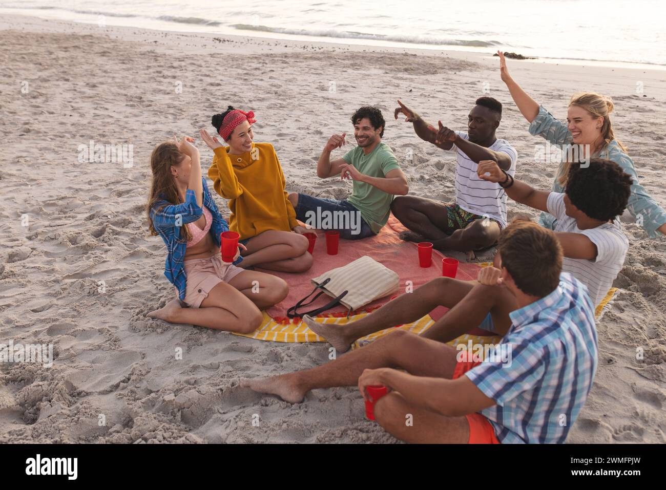 Gruppi diversi di amici si godono una riunione sulla spiaggia Foto Stock