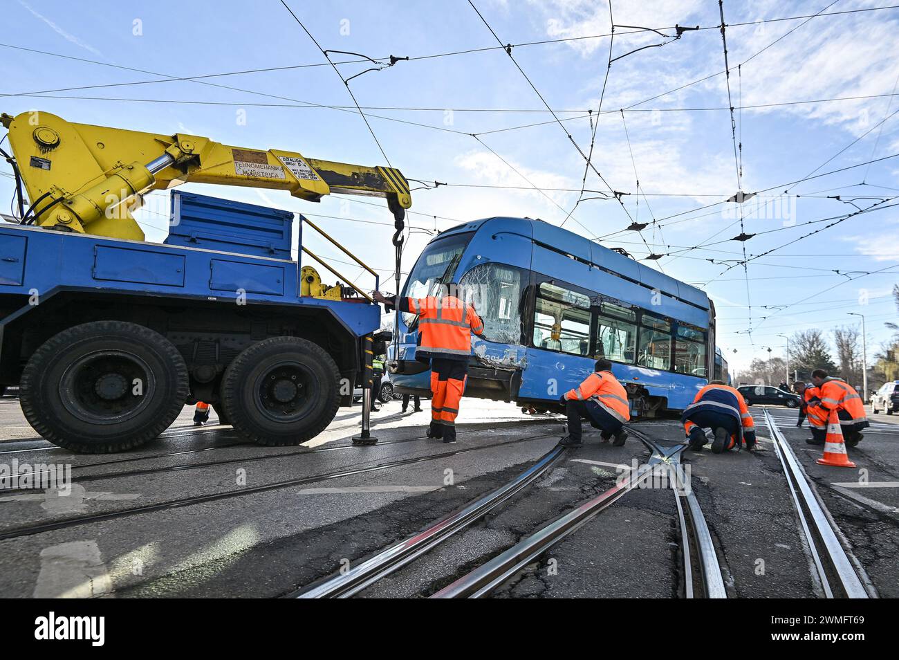 Zagabria, Croazia. 26 febbraio 2024. Il personale di servizio del sistema di trasporto pubblico di Zagabria (ZET) sta lavorando su un tram deragliato per rimetterlo sui binari del sito di un incidente che ha coinvolto la collisione tra due tram, a Zagabria, in Croazia, il 26 febbraio 2024. Un incidente stradale si verificò all'incrocio tra Vukovar Street e Marin Drzic Avenue quando il tram deragliò e si scontrò con un altro tram. Fortunatamente, nessuno è rimasto ferito. Foto: Neva Zganec/PIXSELL credito: Pixsell/Alamy Live News Foto Stock