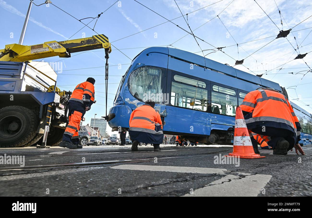 Zagabria, Croazia. 26 febbraio 2024. Il personale di servizio del sistema di trasporto pubblico di Zagabria (ZET) sta lavorando su un tram deragliato per rimetterlo sui binari del sito di un incidente che ha coinvolto la collisione tra due tram, a Zagabria, in Croazia, il 26 febbraio 2024. Un incidente stradale si verificò all'incrocio tra Vukovar Street e Marin Drzic Avenue quando il tram deragliò e si scontrò con un altro tram. Fortunatamente, nessuno è rimasto ferito. Foto: Neva Zganec/PIXSELL credito: Pixsell/Alamy Live News Foto Stock