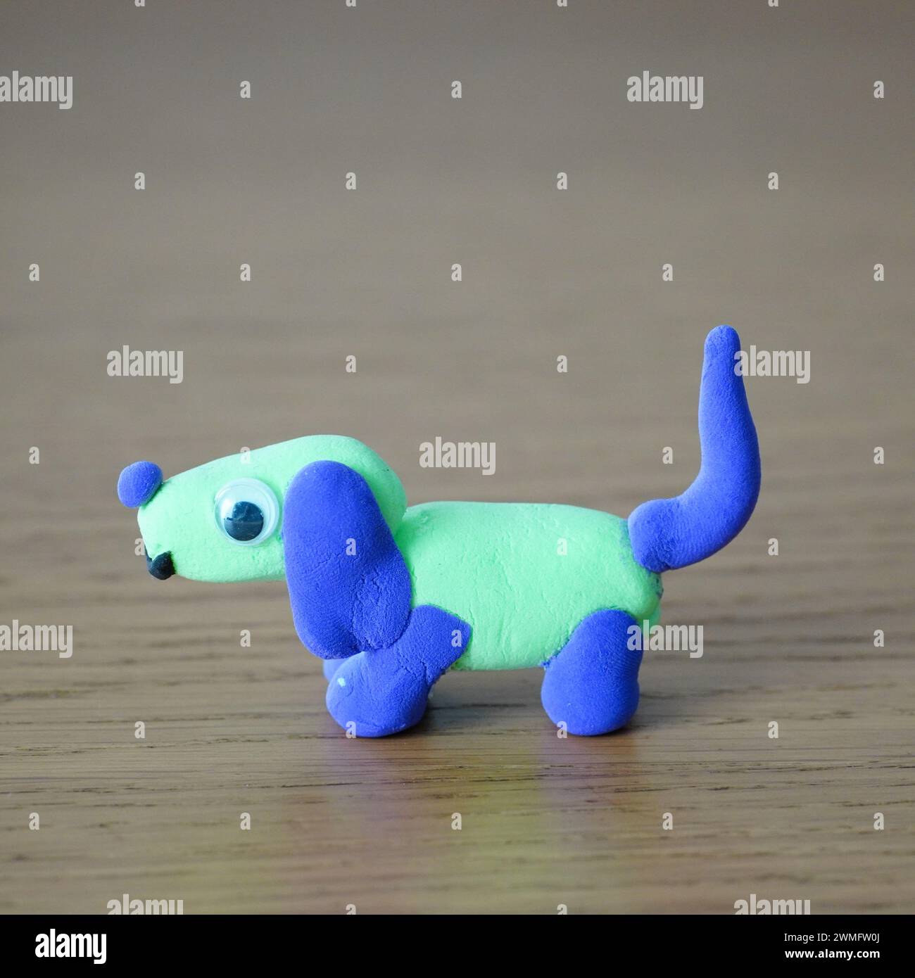 Un cane giocattolo su un tavolo di legno, rivolto di fronte alla fotocamera Foto Stock
