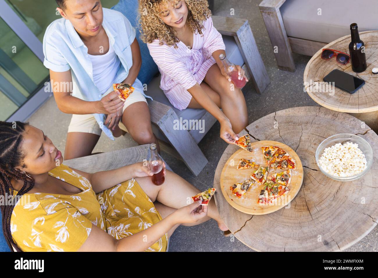 Diversi amici possono gustare insieme un pasto informale all'aperto, mangiando pizza Foto Stock