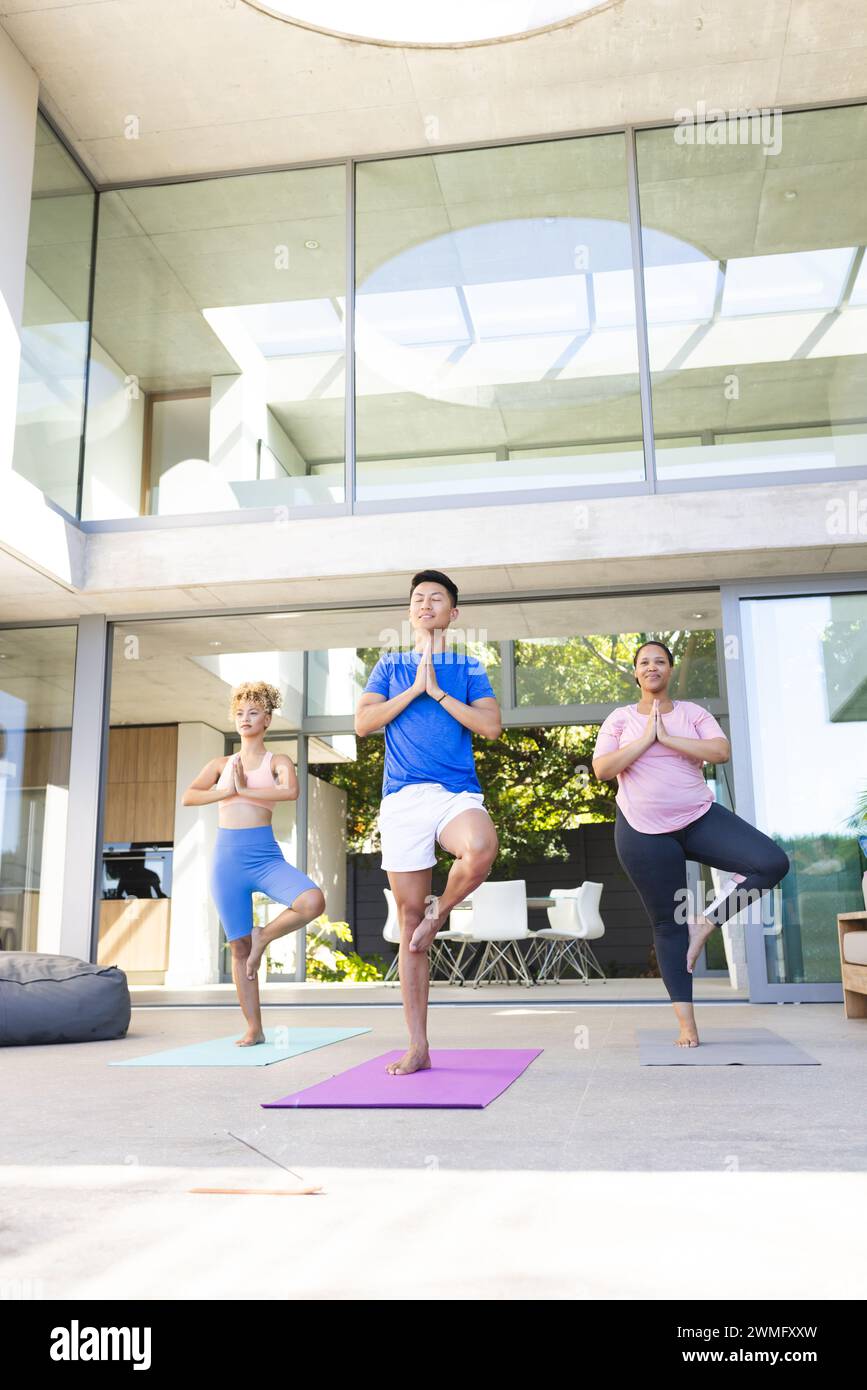 Tre persone diverse praticano yoga all'aperto, con spazio fotocopie Foto Stock