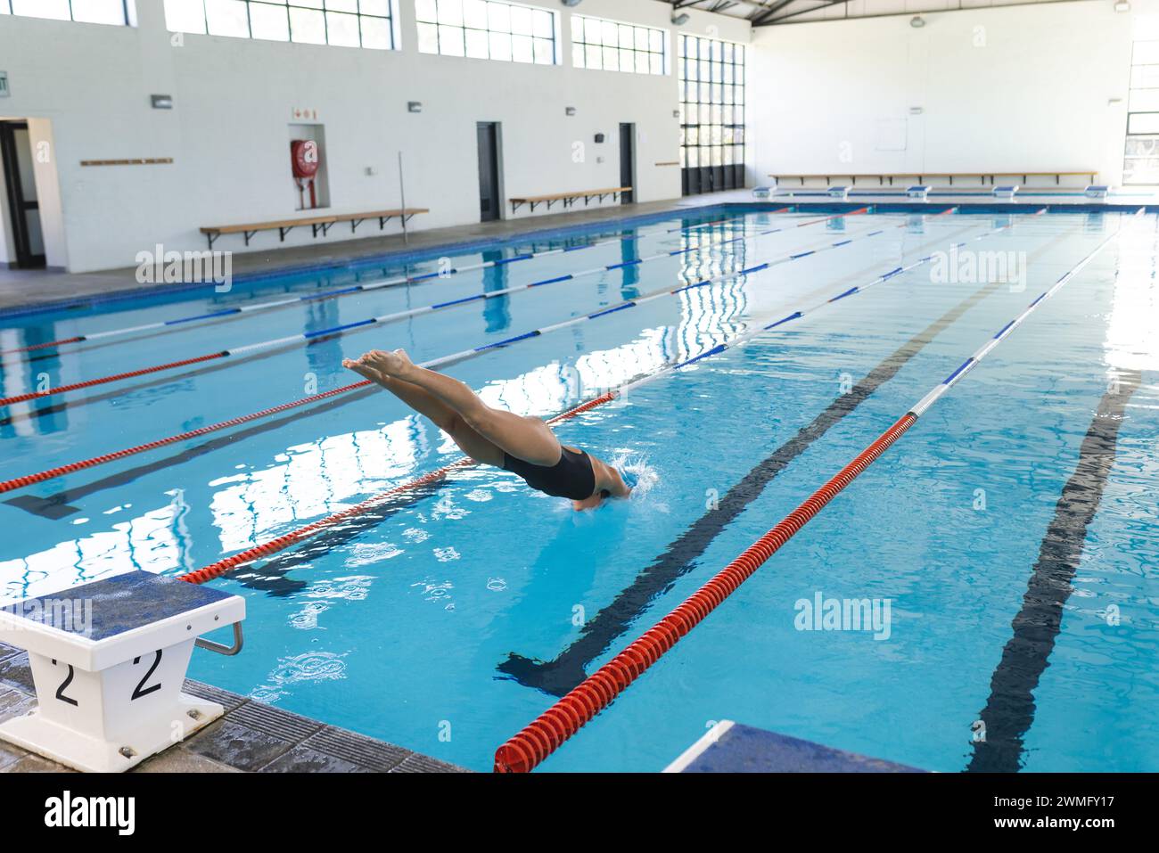 Il nuotatore si tuffa in una piscina coperta presso una struttura sportiva Foto Stock