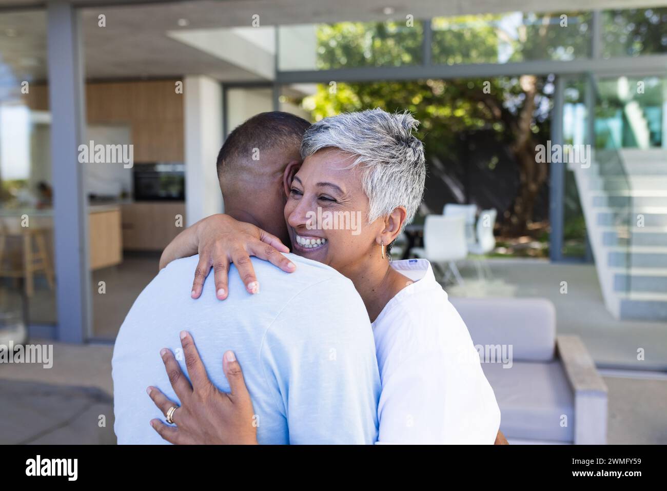 La coppia birazziale abbraccia calorosamente a casa Foto Stock