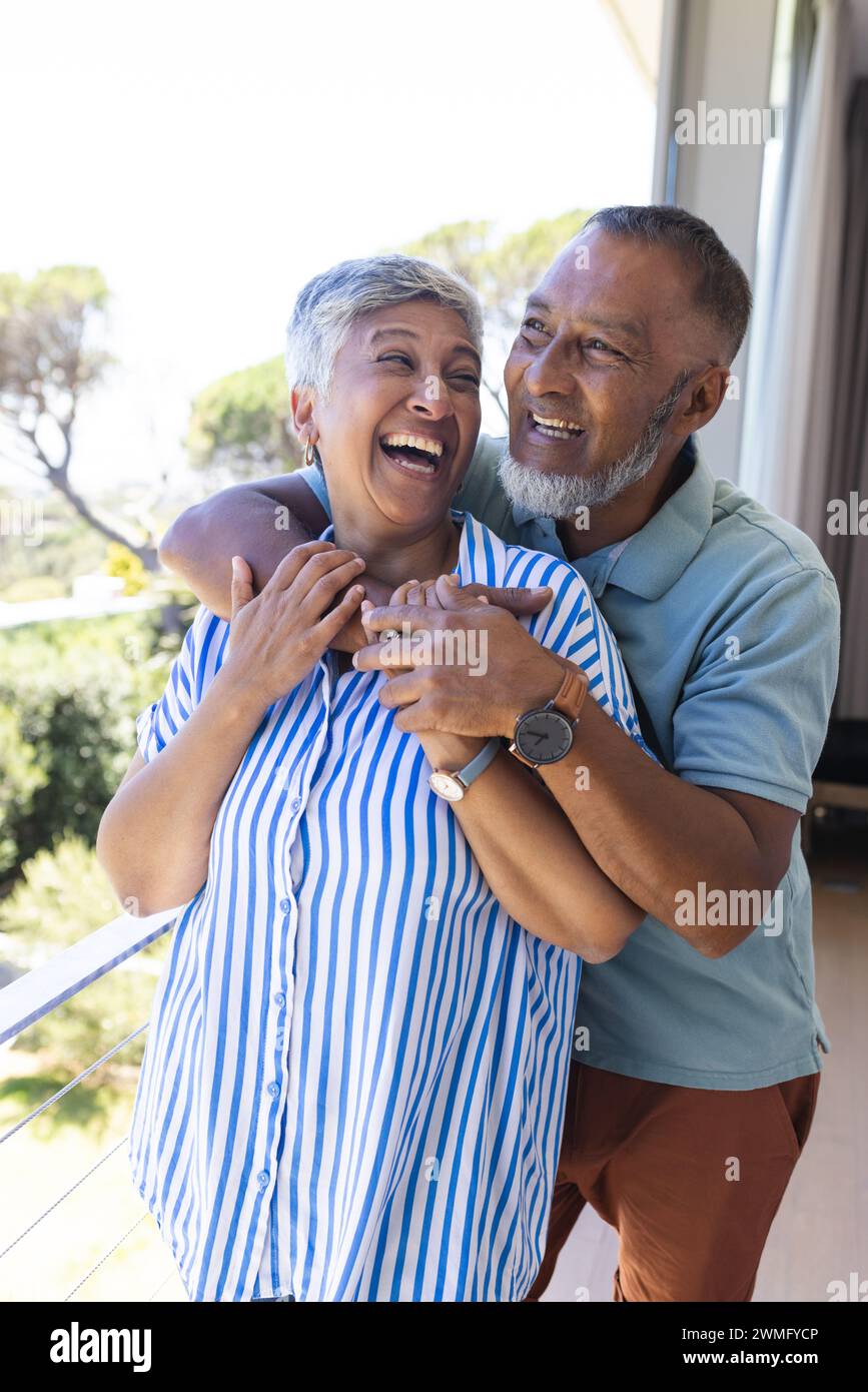 Una coppia birazziale senior condivide un momento di gioia all'aperto Foto Stock