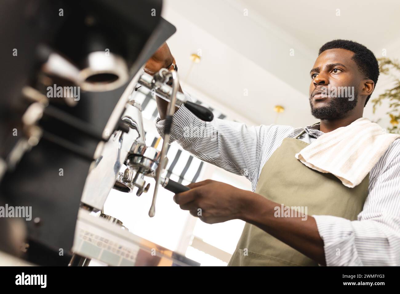 Il barista afro-americano prepara il caffè in una caffetteria, con spazio per le copie Foto Stock