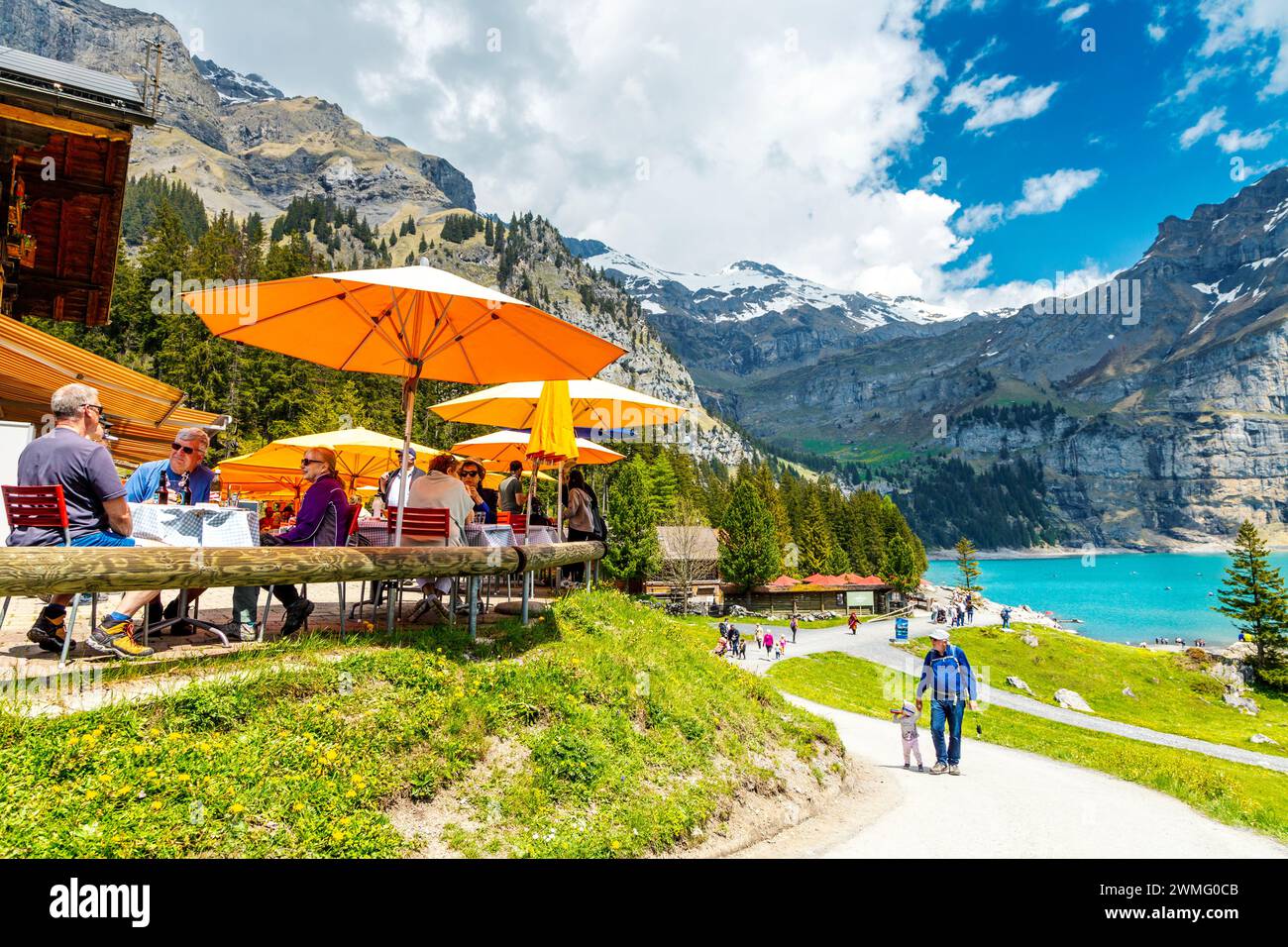 Persone che cenano all'aperto al Berghotel Oeschinensee nel Lago di Oeschinen (Oeschinensee), Svizzera Foto Stock