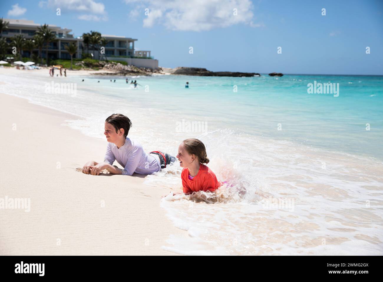 Fratello e sorella giocano insieme a Caribbean Waves Foto Stock