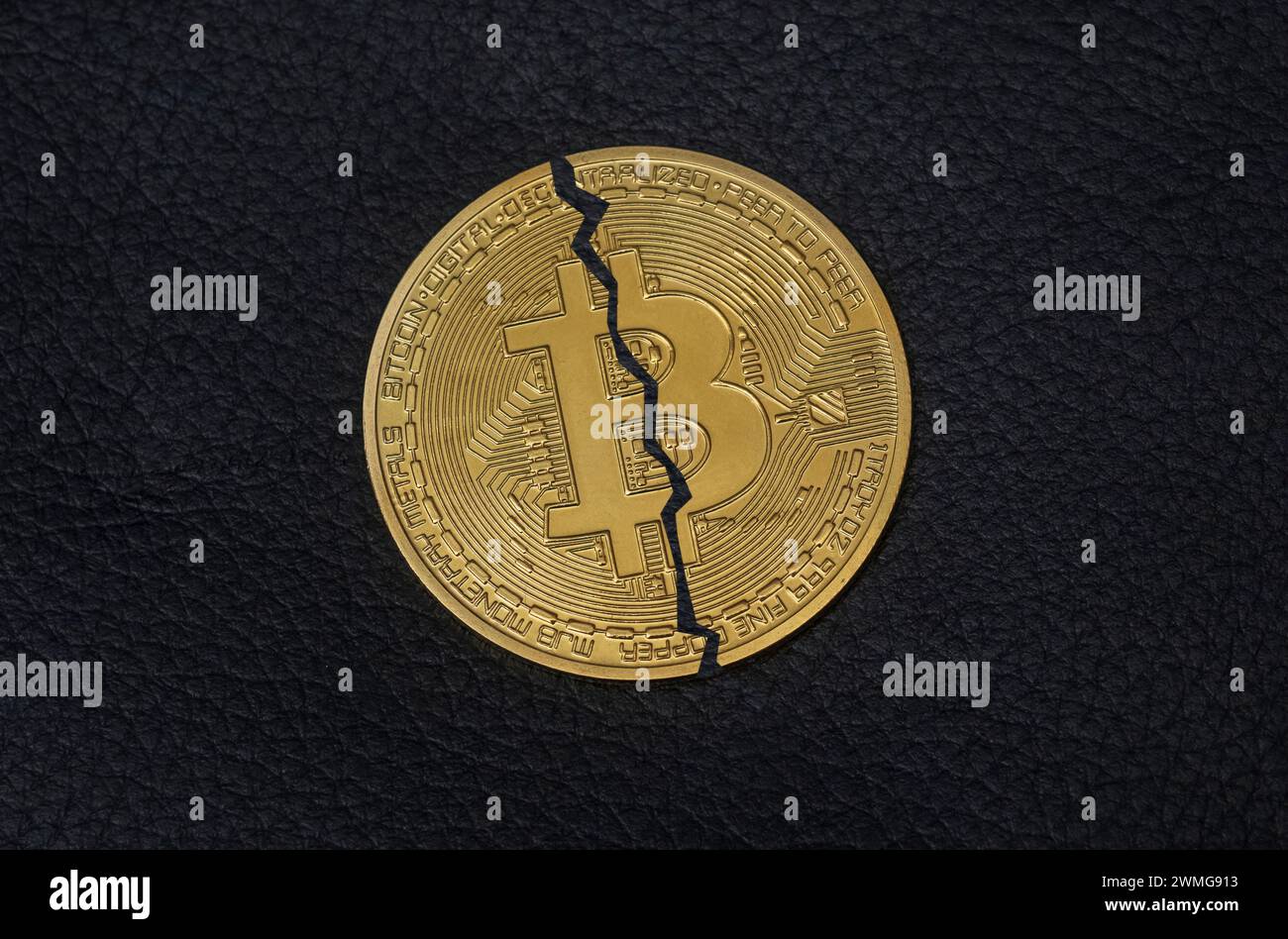 Moneta Bitcoin dimezzata su sfondo nero. Foto simbolo per il Bitcoin Halving Foto Stock