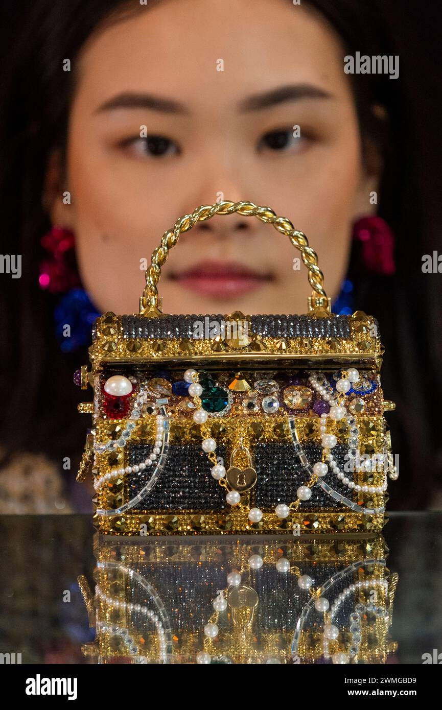 Londra, Regno Unito. 26 febbraio 2024. Un membro dello staff con Judith Leiber: Pochette Gold "Sunken Treasure Chest", 2022, (circa £600 - £800) in anteprima dei prossimi saldi di Bonham per borse firmate e moda. Borse di lusso e design pronti all'uso saranno messi all'asta presso le gallerie Bonhams Knightsbridge il 28 febbraio. Crediti: Stephen Chung / Alamy Live News Foto Stock