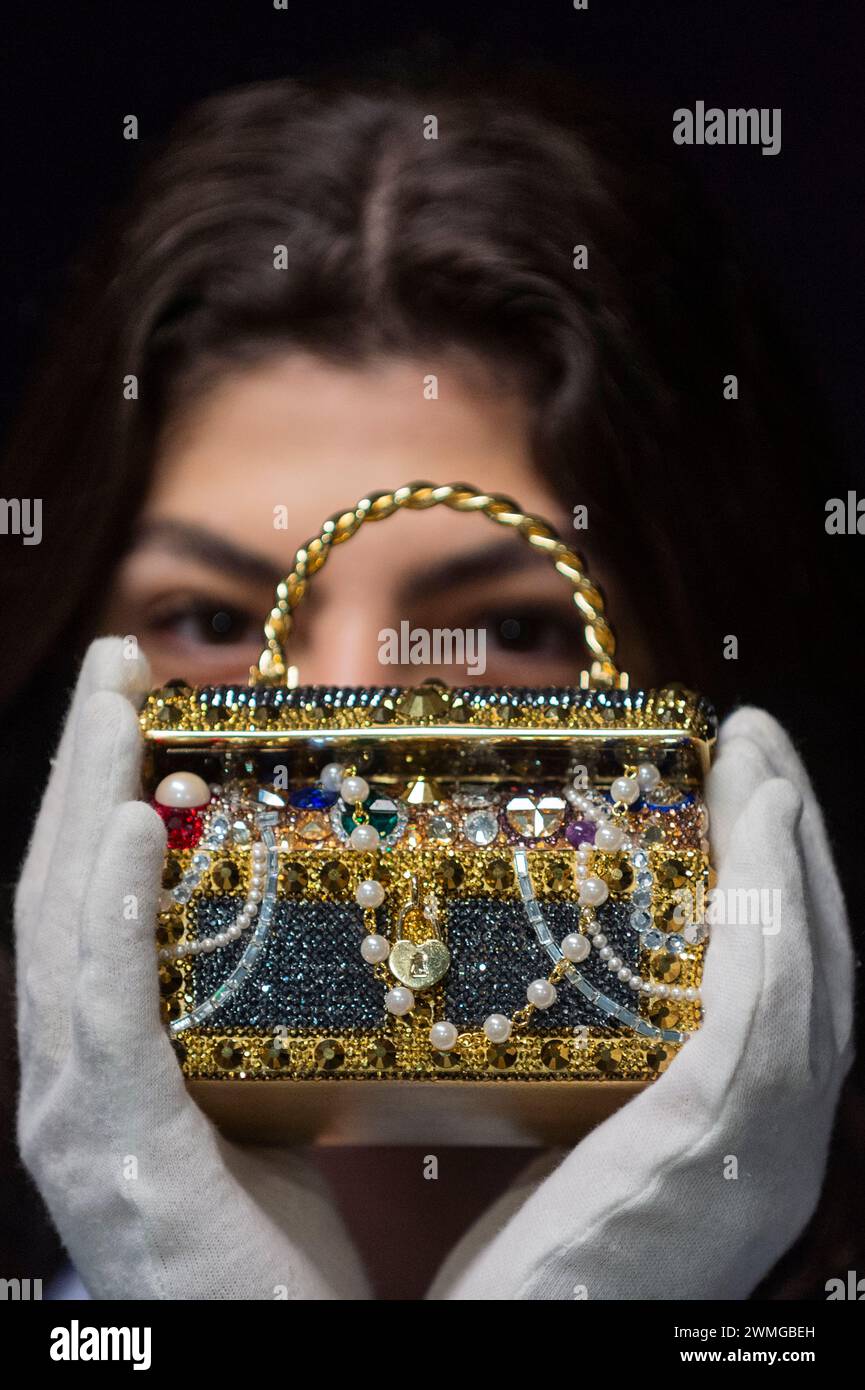 Londra, Regno Unito. 26 febbraio 2024. Un membro dello staff con Judith Leiber: Pochette Gold "Sunken Treasure Chest", 2022, (circa £600 - £800) in anteprima dei prossimi saldi di Bonham per borse firmate e moda. Borse di lusso e design pronti all'uso saranno messi all'asta presso le gallerie Bonhams Knightsbridge il 28 febbraio. Crediti: Stephen Chung / Alamy Live News Foto Stock