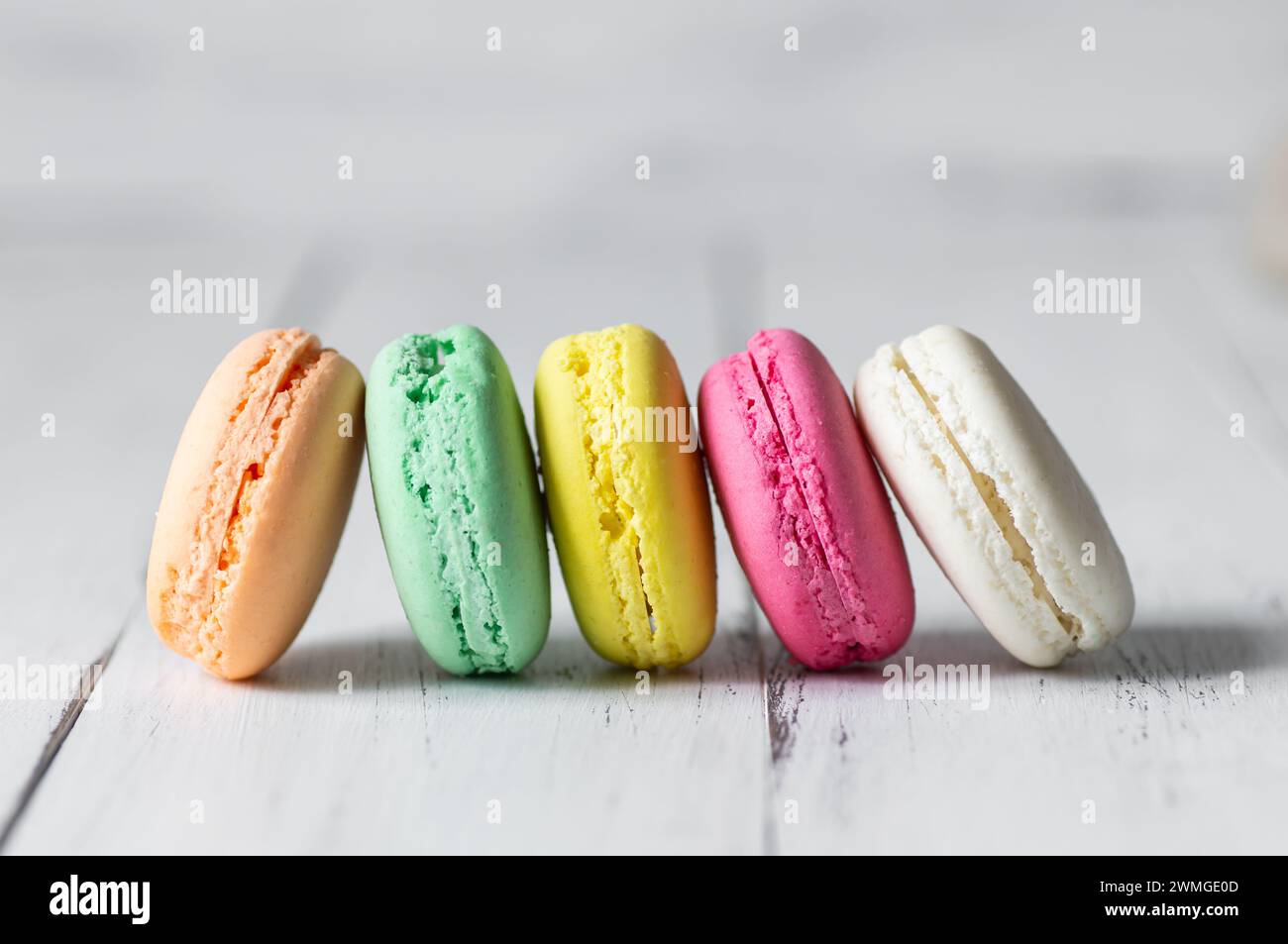 Dessert francese macaron colorati su sfondo rustico Foto Stock