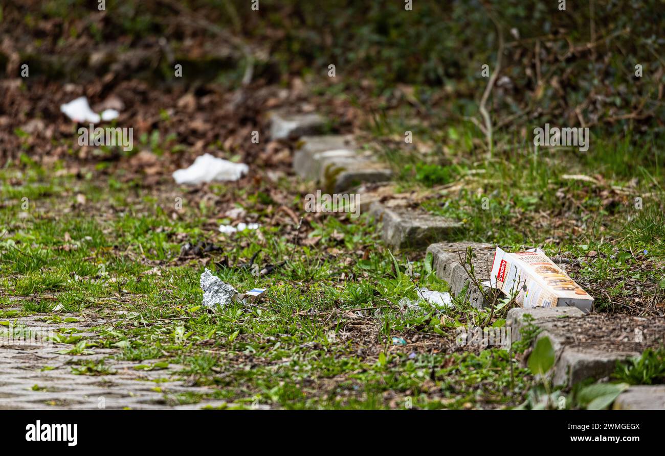 Weggeworfener Müll bei einem Parkplatz. (München, Deutschland, 07.04.2023) Foto Stock