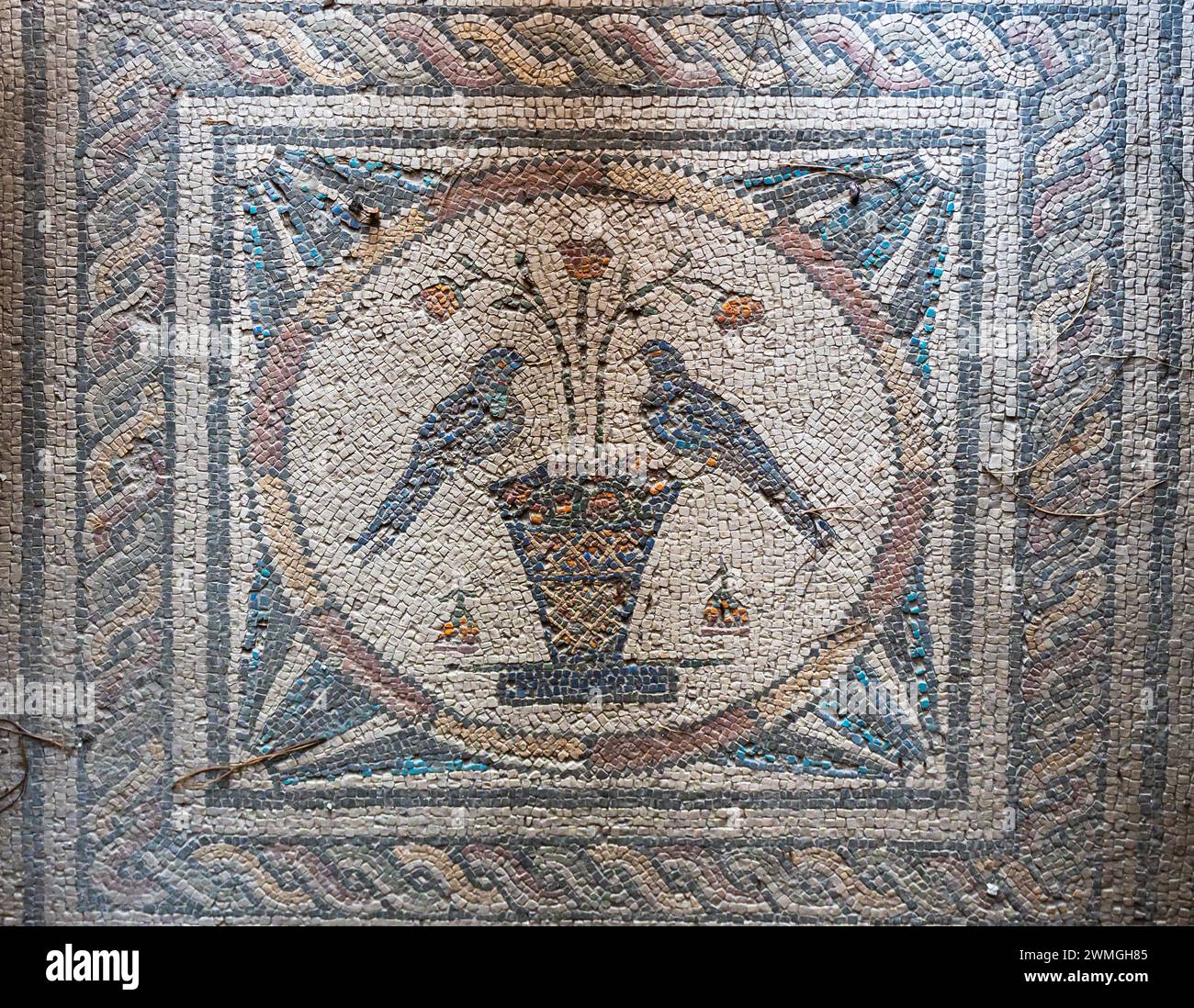 Primo piano sull'antico mosaico romano che mostra uccelli appollaiati su un vaso di fiori Foto Stock