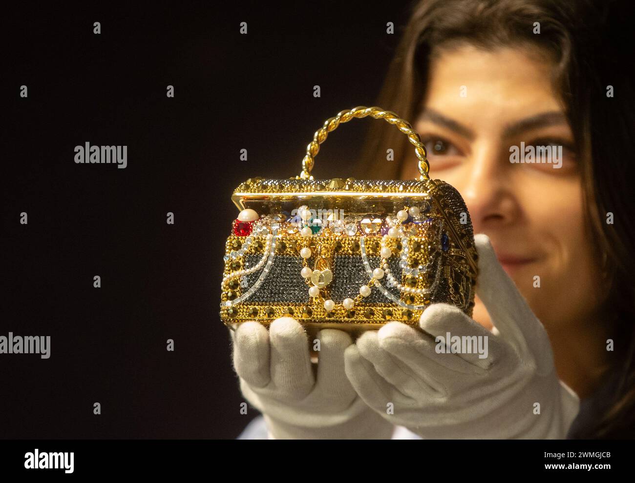 Londra, Inghilterra, Regno Unito. 26 febbraio 2024. Un membro dello staff con Judith Leiber: Pochette Gold "Sunken Treasure Chest", 2022, (circa Â£600 - Â£800) in anteprima delle prossime borse firmate Bonhams e dei saldi alla moda. Borse di lusso e design pronti all'uso saranno messi all'asta presso le gallerie Bonhams Knightsbridge. (Credit Image: © Tayfun Salci/ZUMA Press Wire) SOLO PER USO EDITORIALE! Non per USO commerciale! Crediti: ZUMA Press, Inc./Alamy Live News Foto Stock