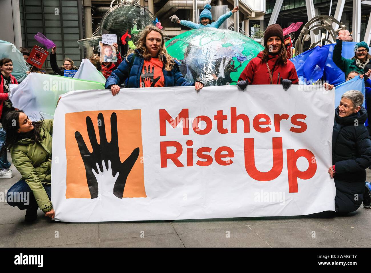 Londra, Regno Unito. 26 febbraio 2024. XR (Extinction Rebellion) "Mothers Rise Up" protesta di danza intorno a un gigantesco globo gonfiabile di fronte all'edificio Lloyds di Londra nella City di Londra, parte della settimana assicurativa di azione di Extinction Rebellion UK. Il gruppo mira a convincere Lloyds di Londra a smettere di assicurare nuovi combustibili fossili. Crediti: Imageplotter/Alamy Live News Foto Stock