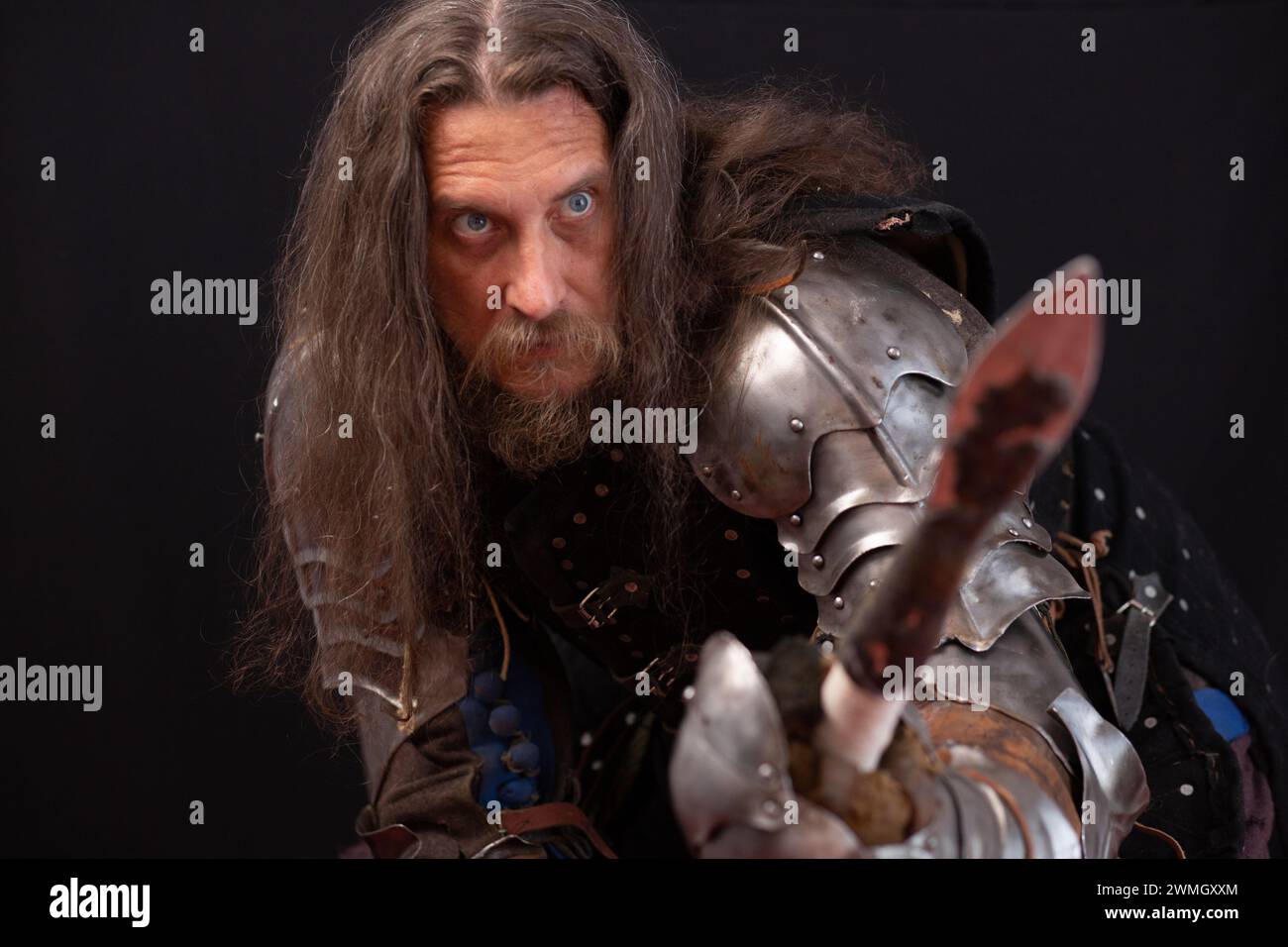 Ritratto di un uomo carismatico vestito da cavaliere medievale con una lancia durante una rievocazione storica. Foto Stock