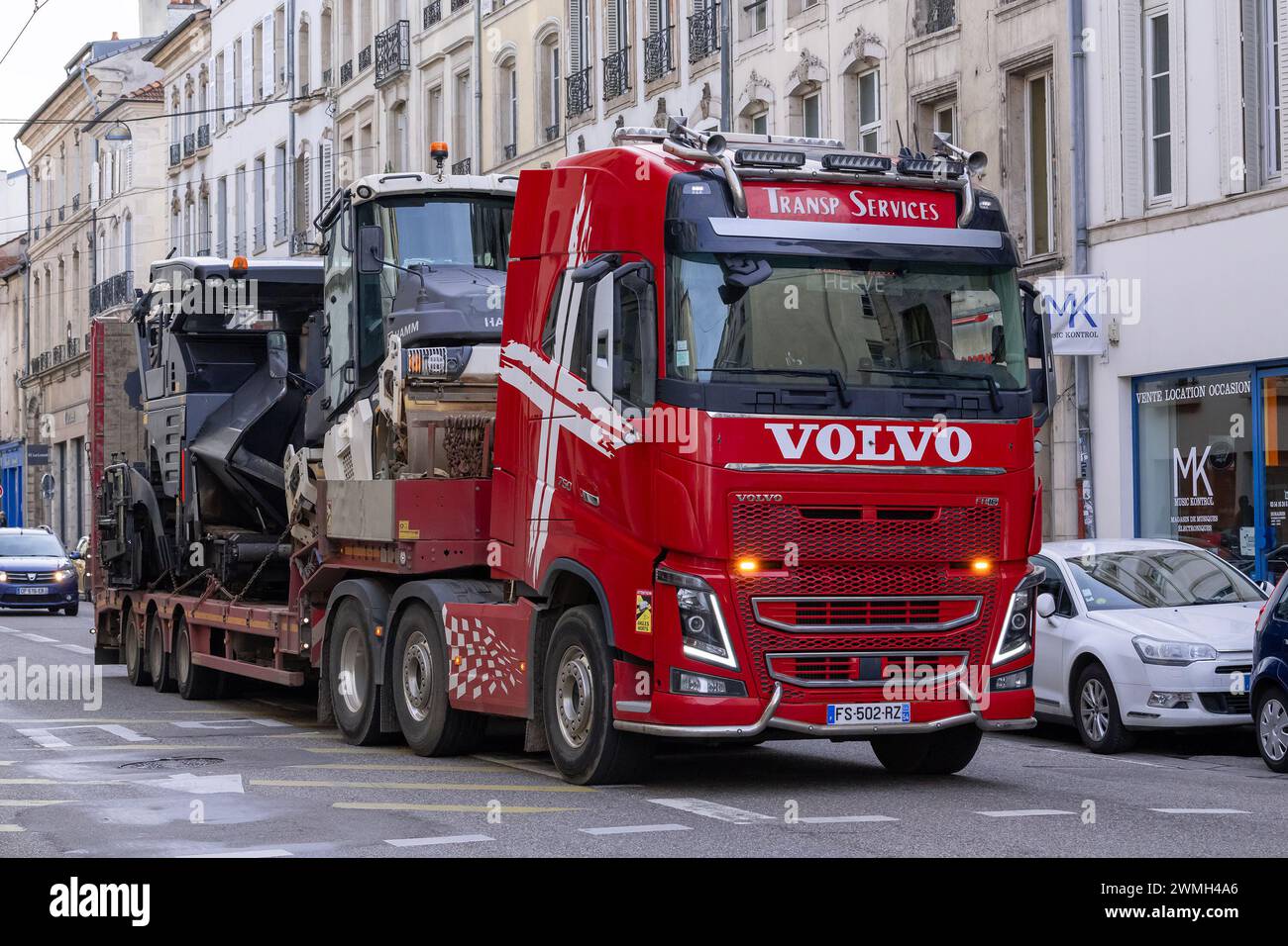 Nancy, Francia - camion per il trasporto pesante Volvo FH 750 rosso con asfaltatrice stradale e rullo tandem su strada. Foto Stock