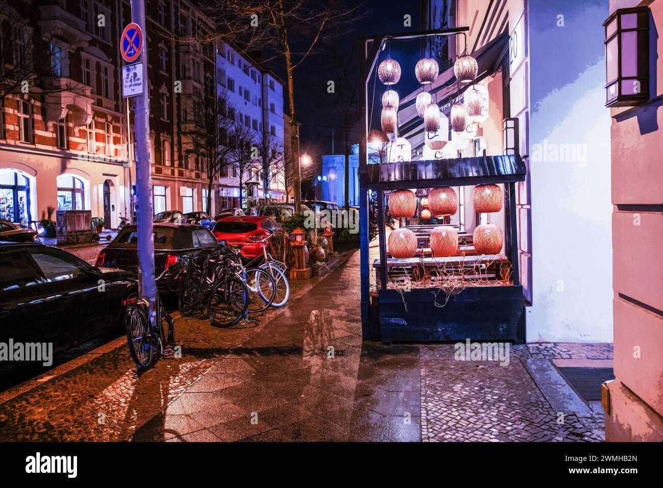 Alcune luci del caffè in via Berlino nel centro e biciclette di notte e auto nei parcheggi Foto Stock