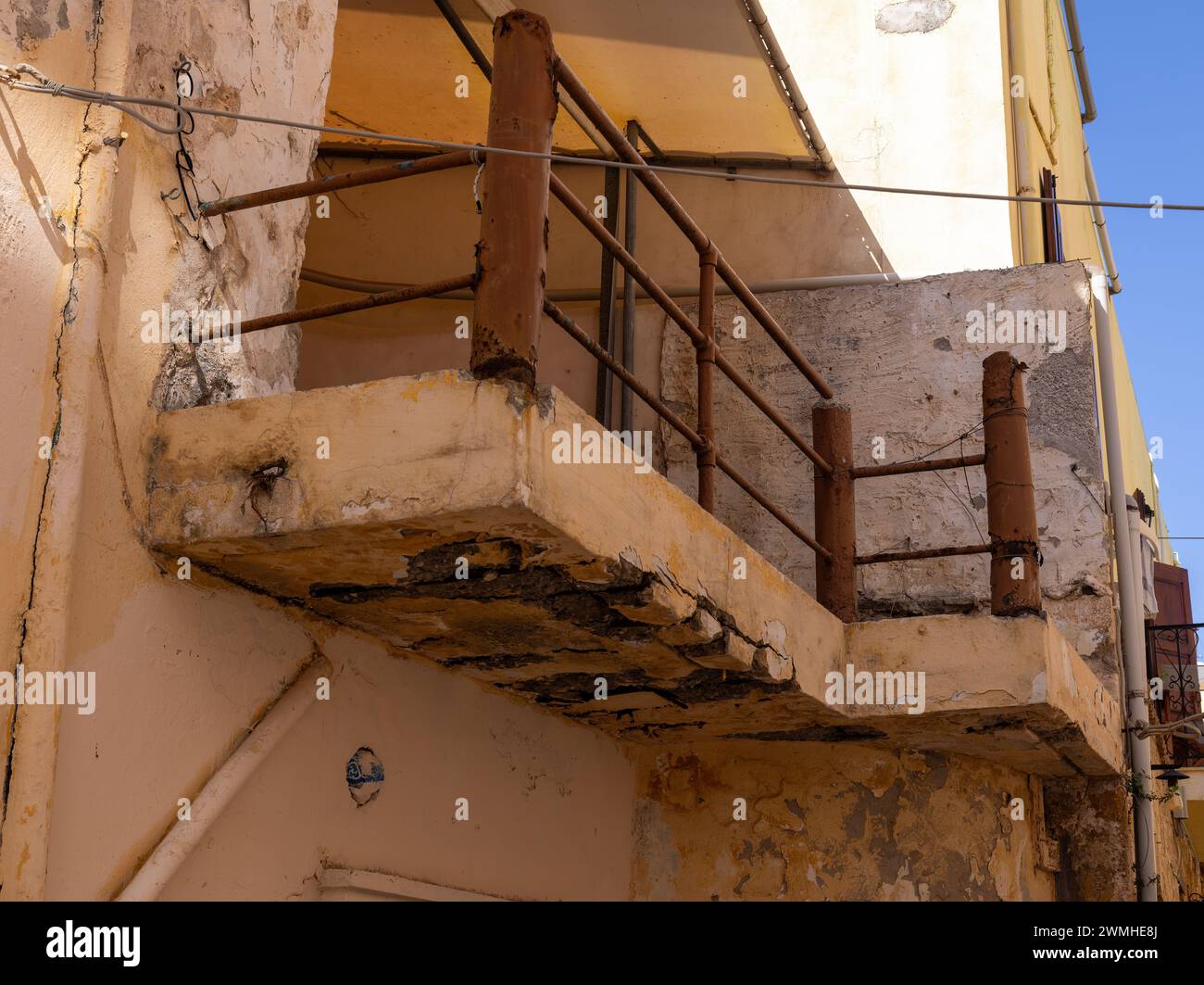 Balcone che necessita di lavori di ristrutturazione e che rischia di crollare su una casa dallo stile architettonico del sud Foto Stock