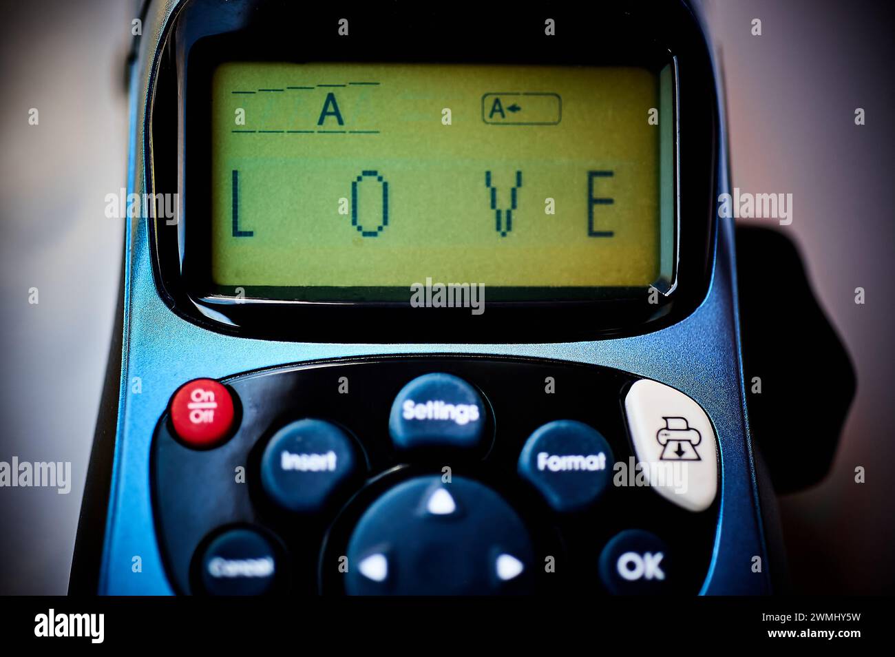 Etichettatrice che mostra la parola amore sul suo schermo, simboleggia un'espressione moderna e tecnologica dell'amore. Foto Stock