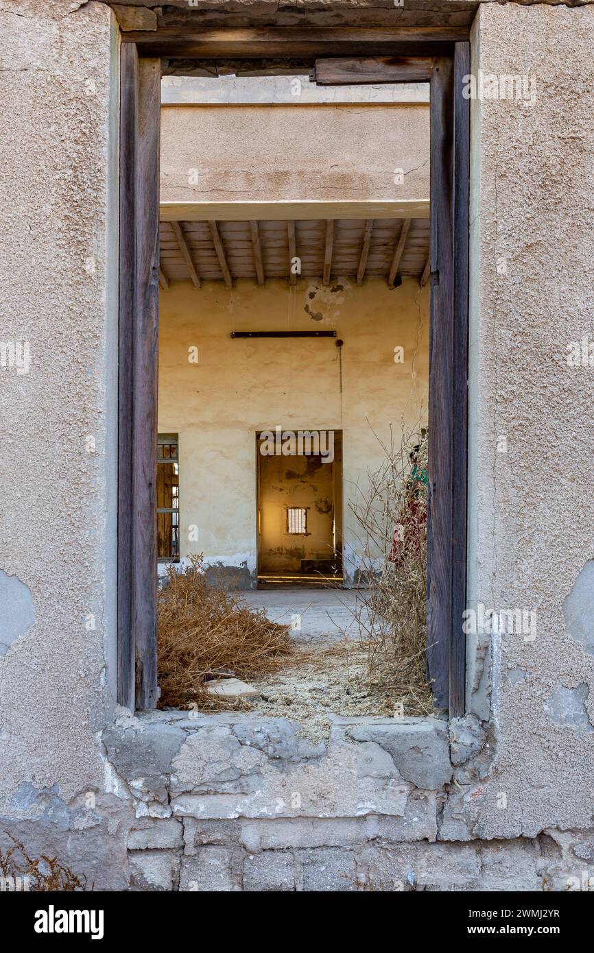 Tunnel simmetrico di intelaiature di porte in edifici abbandonati a al Jazirah al Hamra, città infestata dai fantasmi di Ras al Khaimah, Emirati Arabi Uniti. Foto Stock