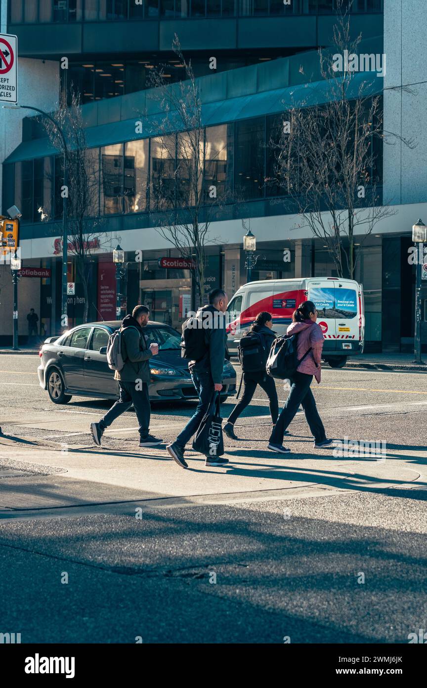 Vancouver, Canada - 16 febbraio 2024: Persone che attraversano Georgia Street all'incrocio con Granville Street. Foto Stock