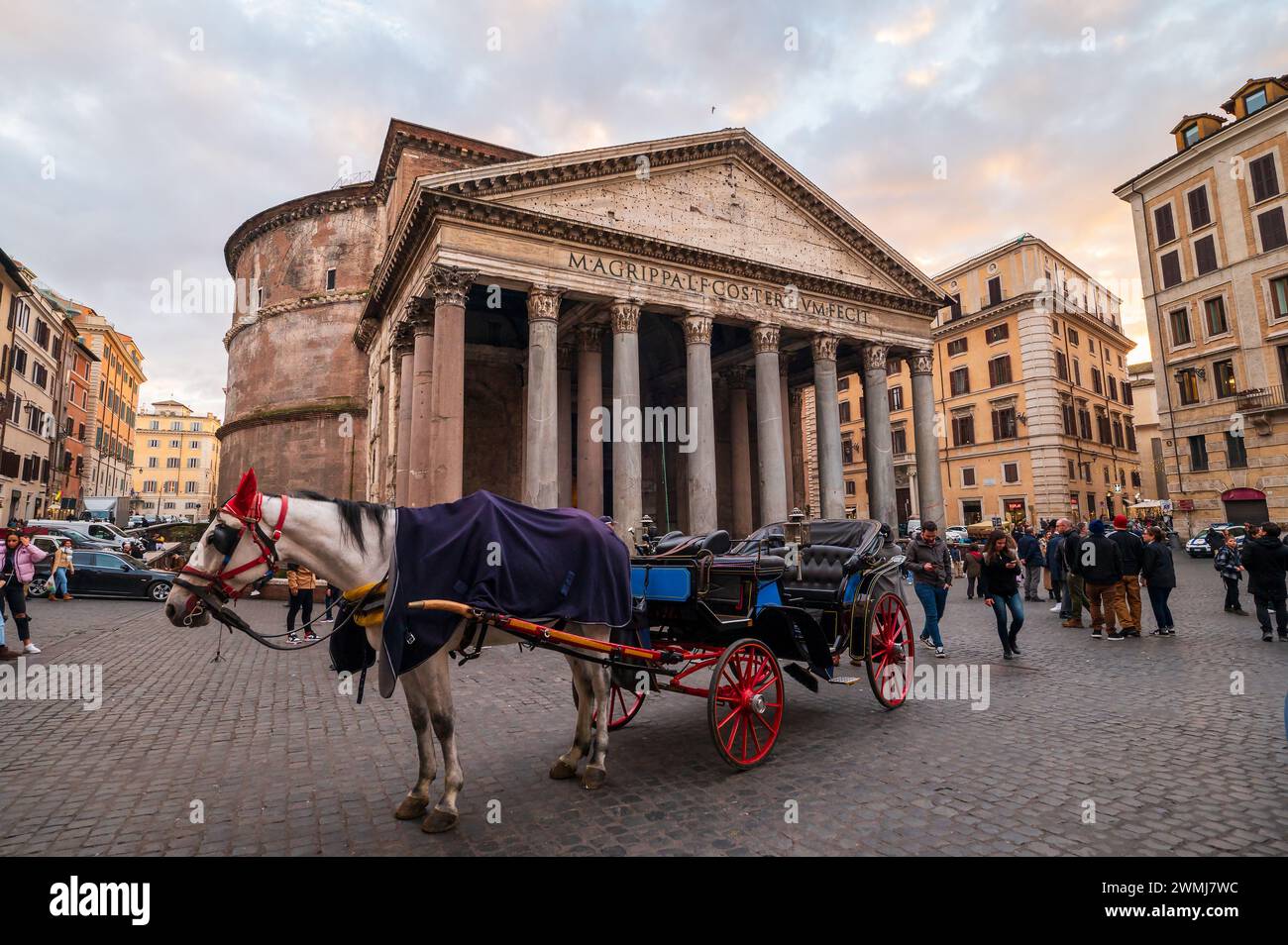 Roma, Italia - 22 dicembre 2022: Una tradizionale carrozza trainata da cavalli attende i passeggeri di fronte allo storico Pantheon nella vivace città Foto Stock