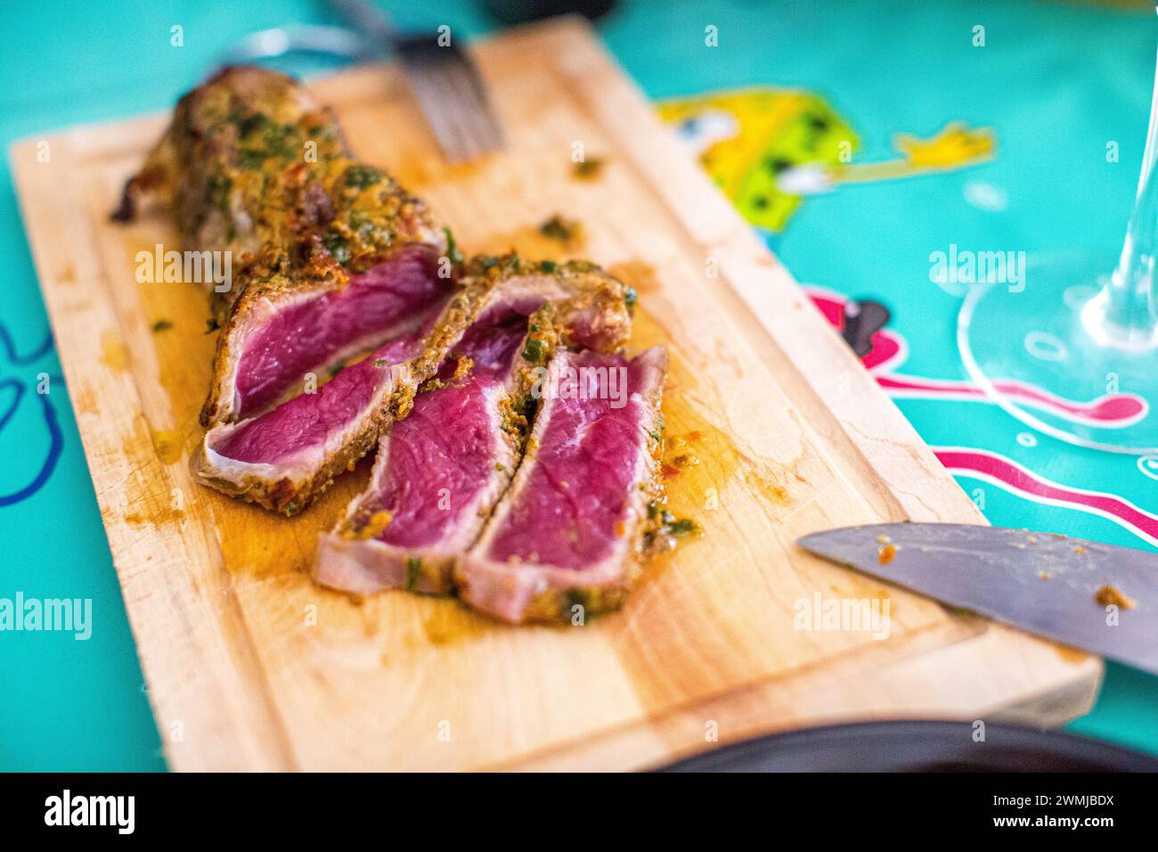 Tataki di manzo di retinta a fette con erbe su un asse di legno, pronto da mangiare. Foto Stock