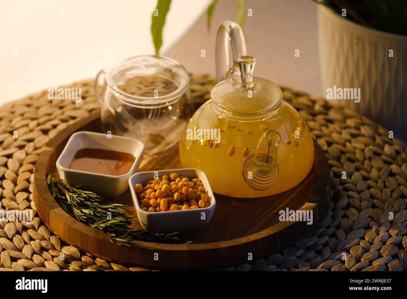Una teiera con tè di spinone marino, miele e un piatto con spinotto marino su un vassoio Foto Stock