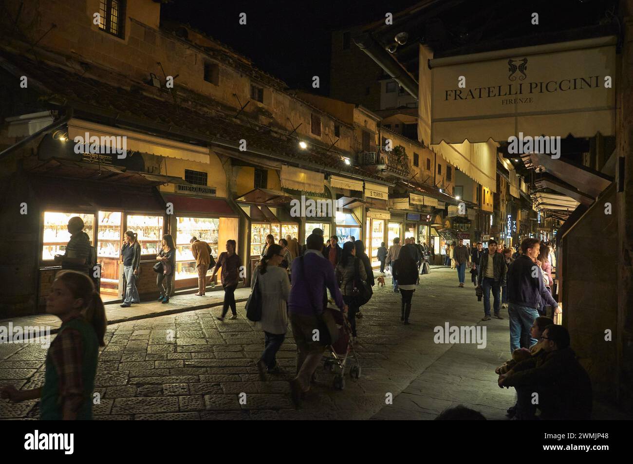 11-07-2013 Firenze, Italia - i pedoni esplorano i negozi lungo il Ponte Vecchio di Firenze, creando un'atmosfera notturna magica Foto Stock