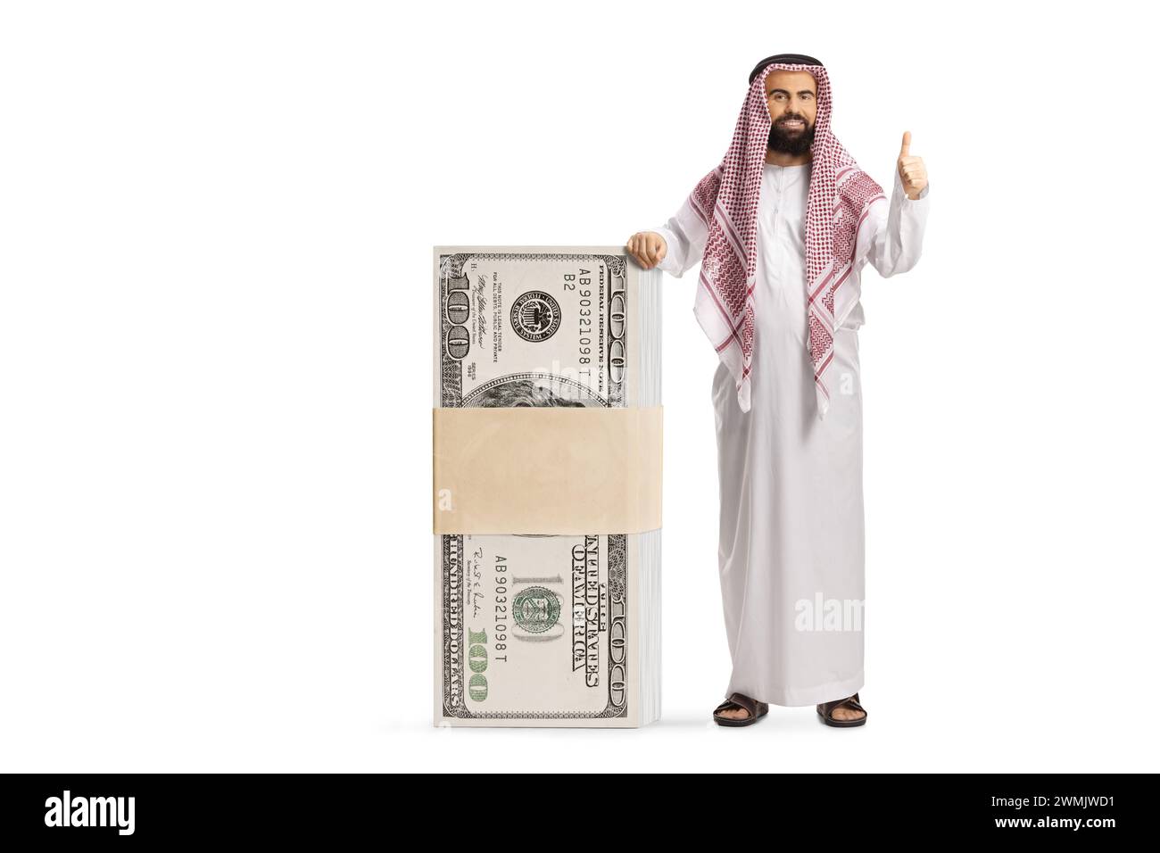 Un uomo arabo saudita barbuto appoggiato su una pila di soldi e con i pollici gestanti isolato su sfondo bianco Foto Stock