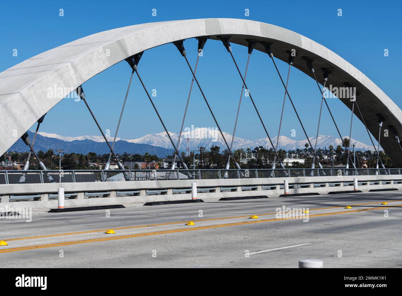 Arco del 6th Street Bridge di Los Angeles con il Monte Baldy innevato e le San Gabriel Mountains sullo sfondo. Foto Stock