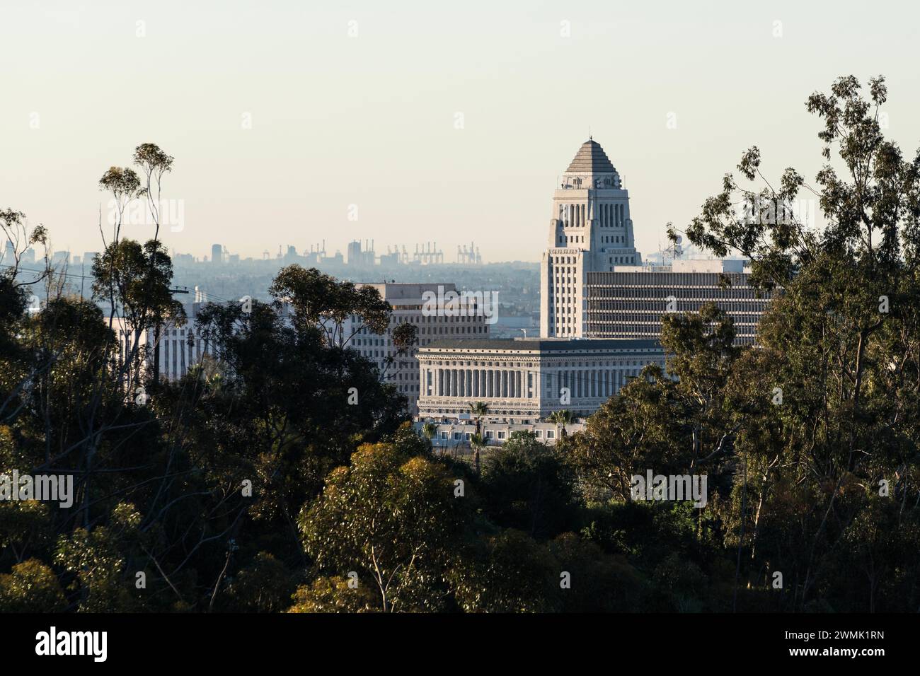 Teleobiettivo del municipio di Los Angeles con gru del porto di Long Beach all'orizzonte. Foto Stock