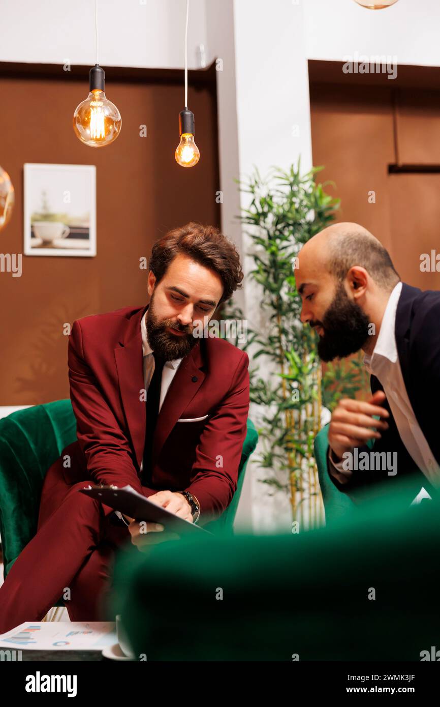 Professionisti che lavorano diligentemente per raggiungere un obiettivo comune di successo aziendale. I colleghi che viaggiano per lavoro per incontrarsi e creare una nuova proficua partnership aziendale, vestiti impeccabilmente con abiti su misura. Foto Stock