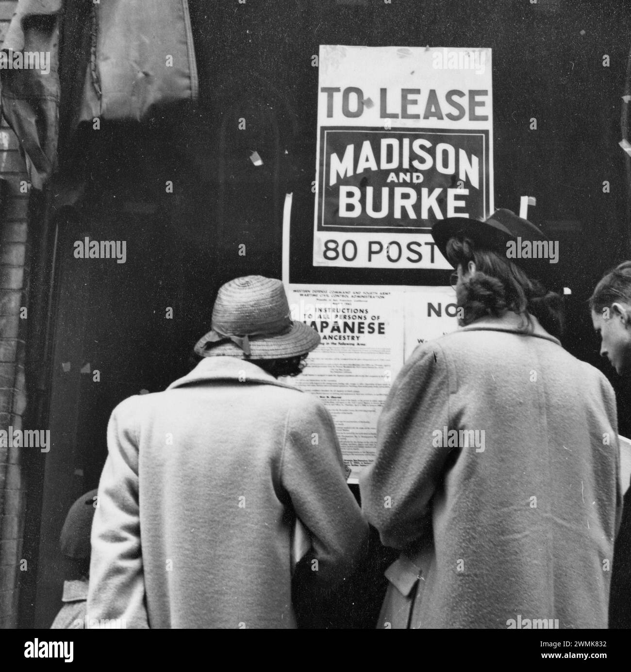 San Francisco, California. Sabato pomeriggio gli acquirenti leggono l'ordine che dirige l'evacuazione di persone di origine giapponese. Questo negozio su Grant Avenue a Chinatown è stato lasciato libero da un commerciante d'arte di origine giapponese. Gli sfollati saranno ospitati nei centri dell'autorità per il trasferimento di guerra per tutta la durata. Date in cui questo articolo è stato prodotto o creato il 17 aprile 1942. Foto Stock