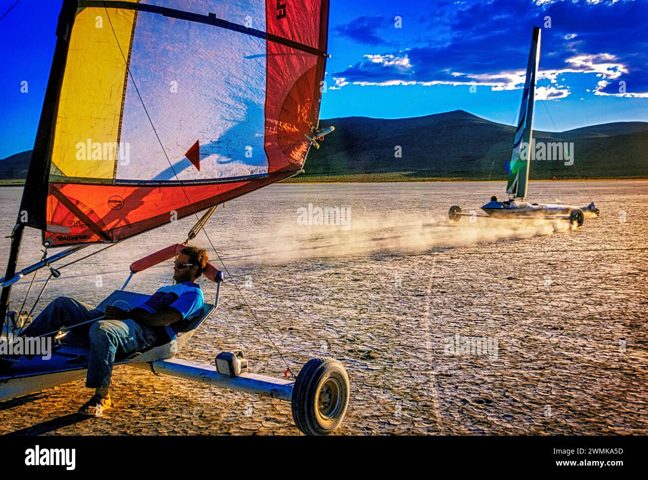Gli yacht terrestri corrono il vento e l'uno sull'altro attraverso il terreno pianeggiante e polveroso di Alvord Desert playa. Gli appassionati di sport si radunano nell'antico letto del lago in... Foto Stock