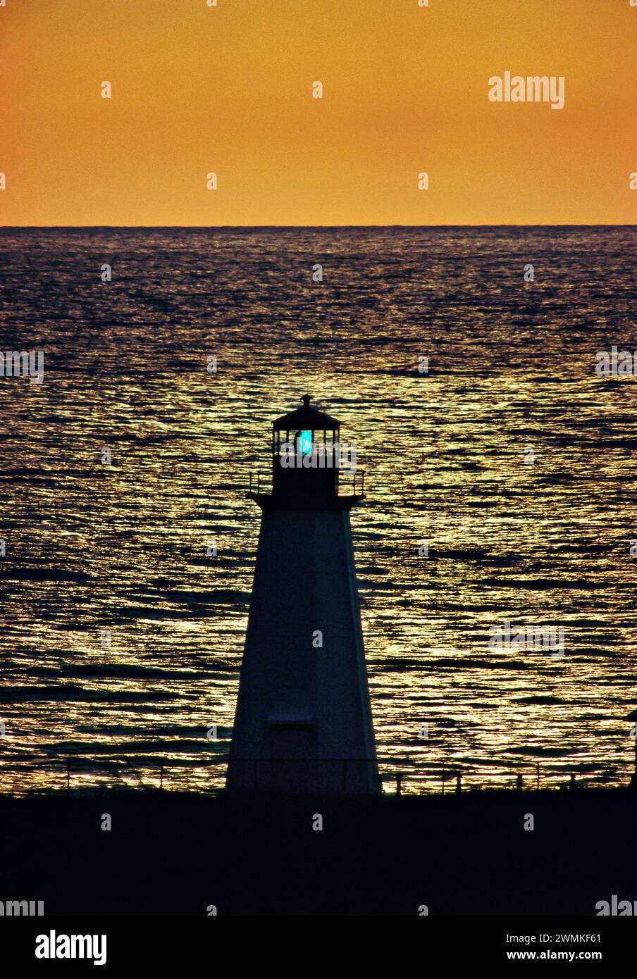 Faro sagomato illuminato al tramonto, vicino a Cape Rouge, nuova Scozia; Cape Breton, nuova Scozia, Canada Foto Stock