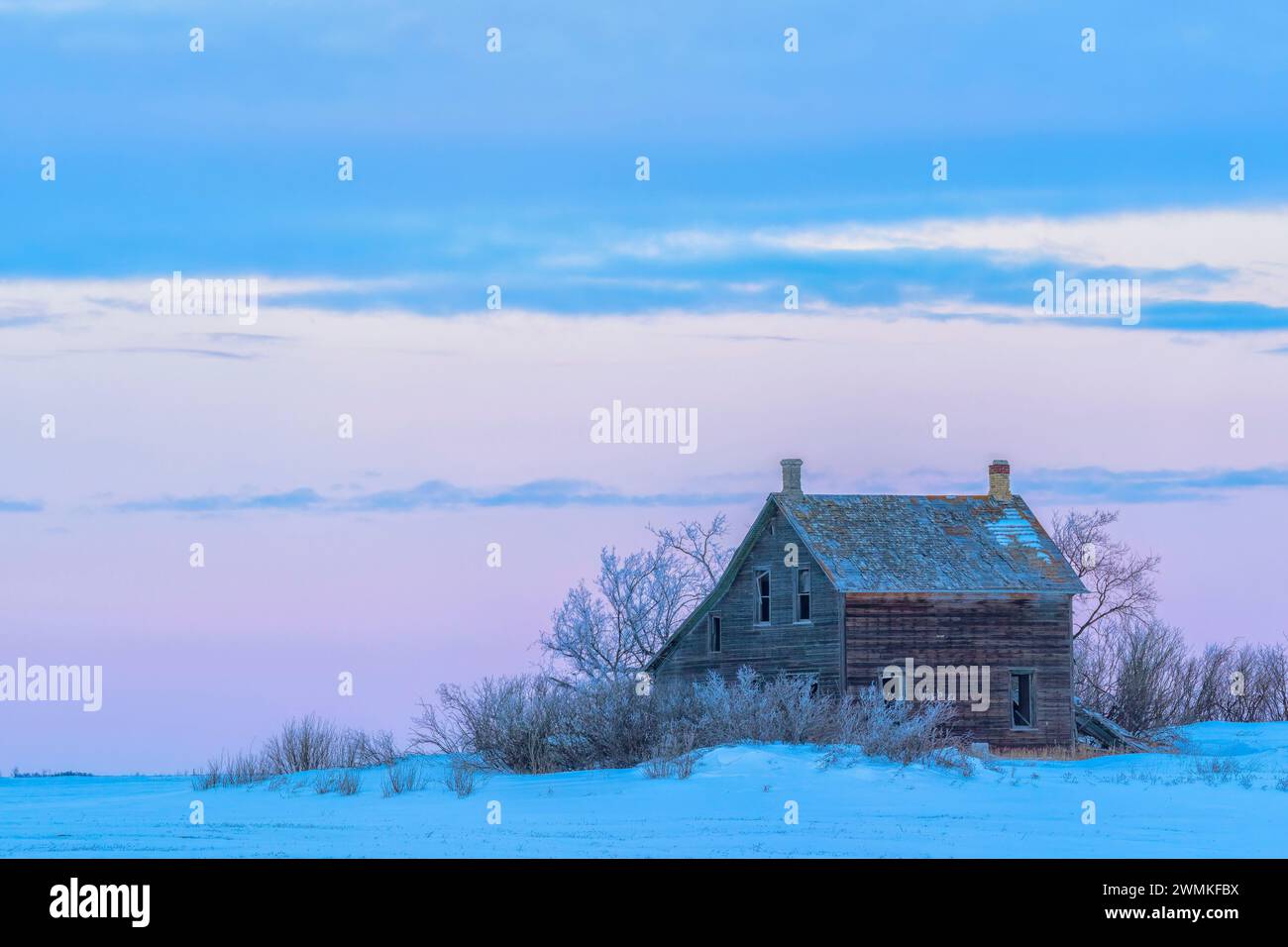 Cabina abbandonata in un giorno d'inverno nella città di Yorkton al tramonto; Saskatchewan, Canada Foto Stock