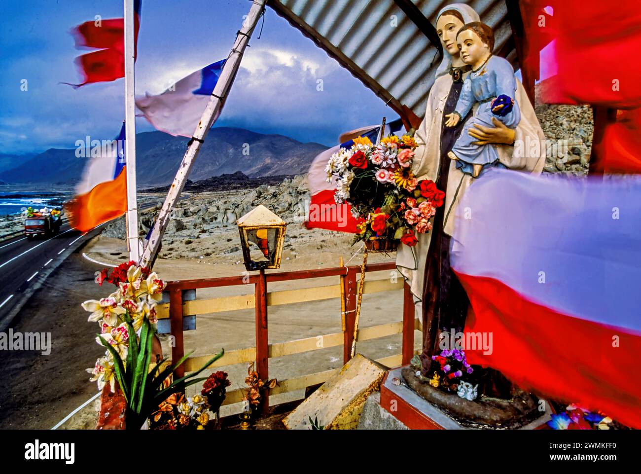 Bandiere e statue decorano un colorato altare lungo la strada in una regione desolata del Cile settentrionale. Santuari o animitas sono una tradizione comune di memoria... Foto Stock