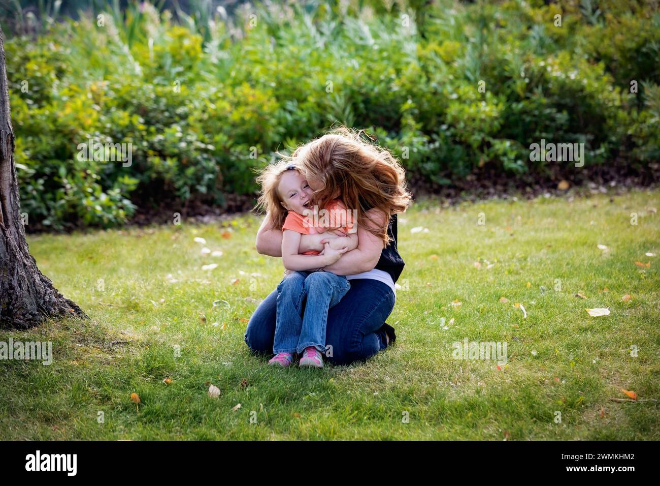 Madre che gioca con la figlia dell'infanzia all'aperto in un parco cittadino durante un caldo pomeriggio autunnale; Leduc, Alberta, Canada Foto Stock