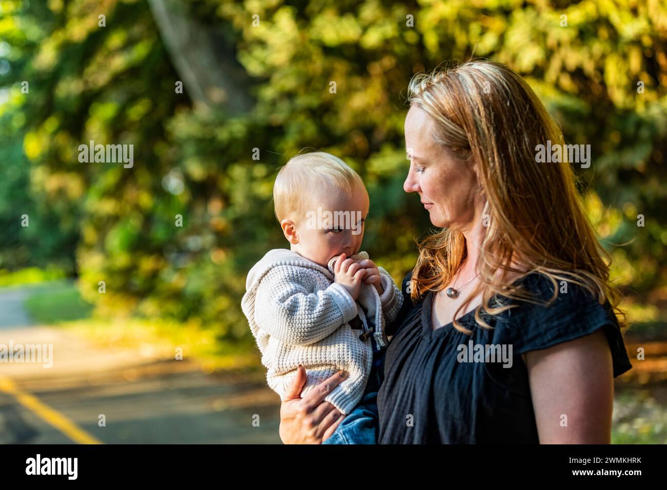 Madre trascorre del tempo di qualità con suo figlio che ha la sindrome di Down in un parco cittadino durante una giornata autunnale; Leduc, Alberta, Canada Foto Stock