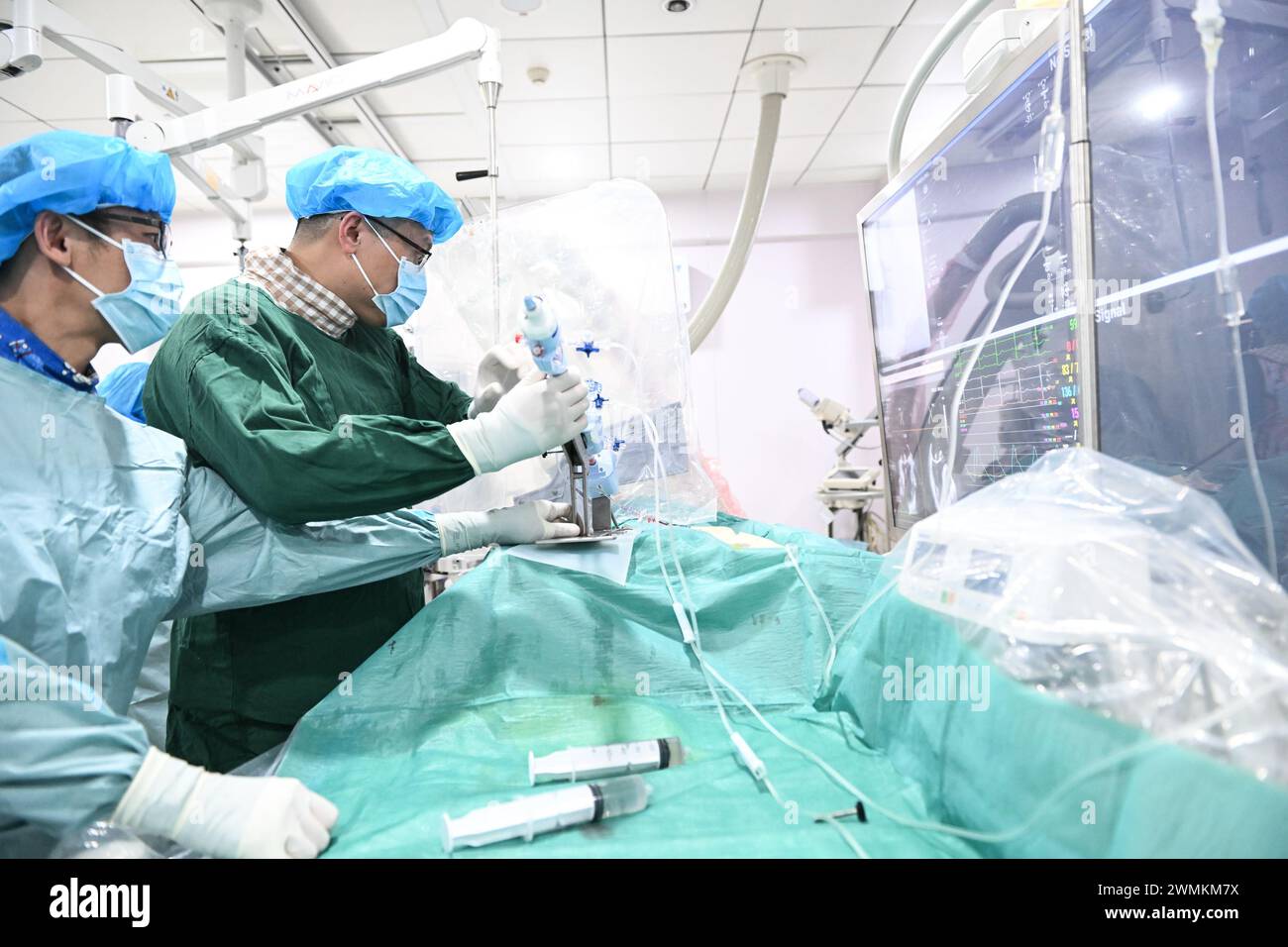 (240227) -- NANCHINO, 27 febbraio 2024 (Xinhua) -- Zhang Junjie (R) e il suo collega eseguono un intervento chirurgico su un paziente presso il Nanjing First Hospital di Nanchino, provincia di Jiangsu, Cina orientale, 20 febbraio 2024. Zhang Junjie, deputato del XIV Congresso Nazionale del popolo (NPC), è un cardiologo e vicepresidente del primo ospedale di Nanchino. È stato impegnato nella diagnosi interventistica e nel trattamento di malattie cardiache coronariche, valvulopatia e cardiomiopatia ostruttiva ipertrofica, studiando diligentemente tecnologie mediche avanzate e trattando pazienti con squisite competenze mediche. Foto Stock