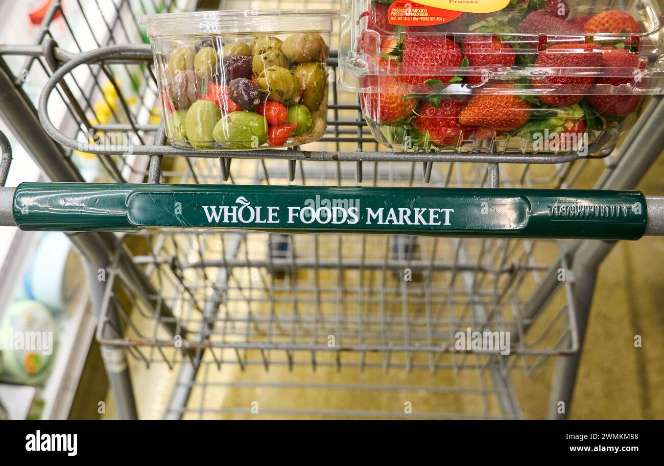 Dallas, Texas, USA - 25 febbraio 2024: Mercato cart of Whole Foods con alimentari. Di proprietà di Amazon, Whole Foods, una catena di alimentari statunitense, vende cibo senza arti Foto Stock