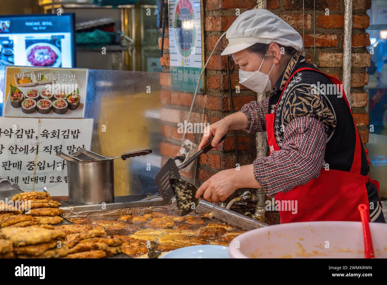 Seoul, Corea del Sud - 11 novembre 2022: Bancarelle di negozi e Street food con molti turisti al mercato di Gwangjang Foto Stock