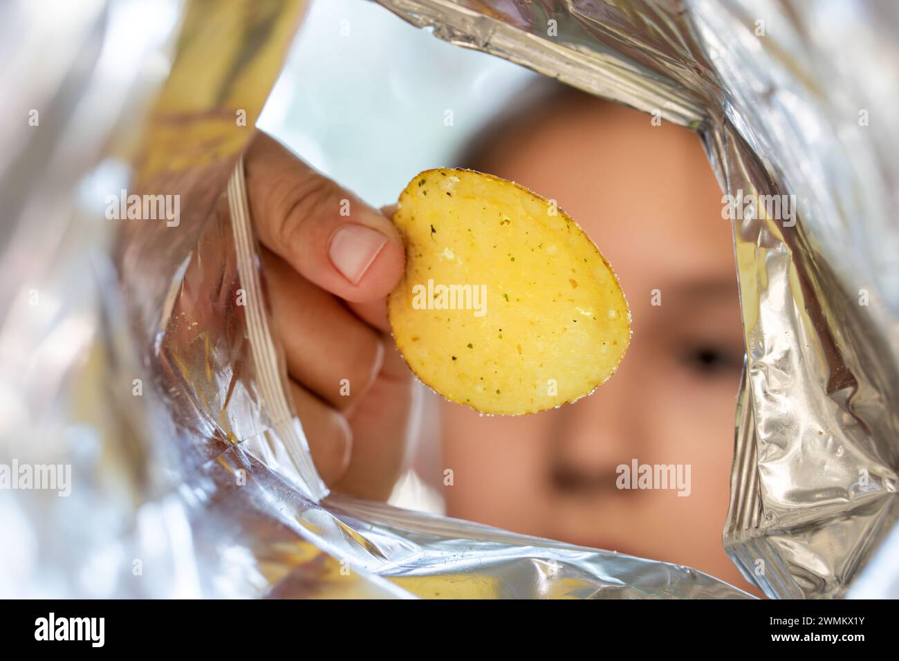 Patatine croccanti in sacchetto di alluminio metallico. Il concetto di cibo e stile di vita non salutari. Confezione di patatine fritte all'interno della confezione Foto Stock