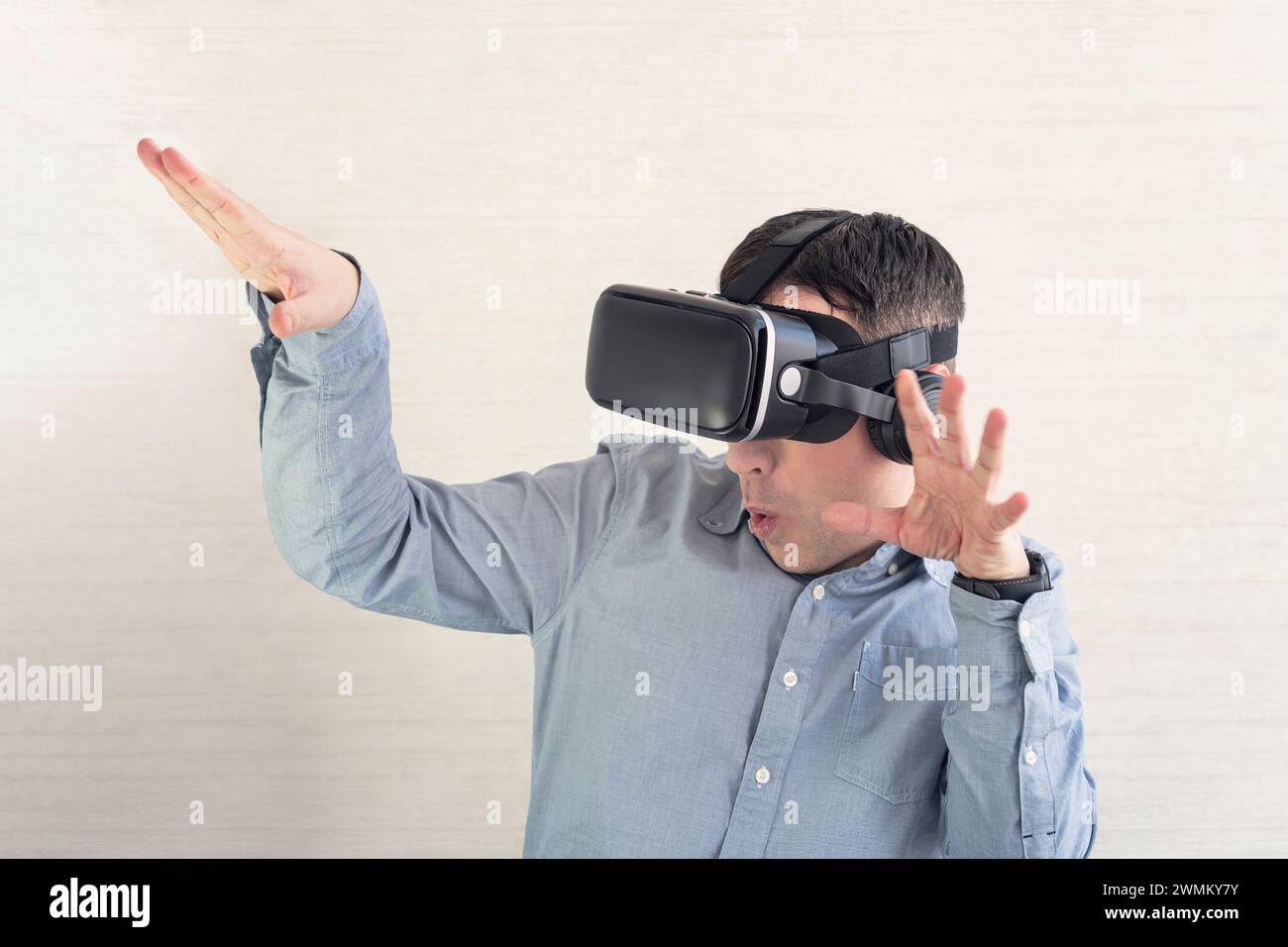 Un uomo felice negli occhiali VR sta urlando. Concetto di emozioni umane, espressione facciale, gadget e tecnologie moderne. La cuffia maschile in 3D sta ballando sulla w Foto Stock